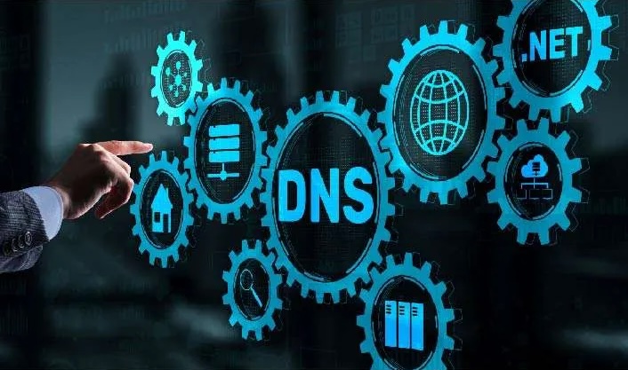 A hand in a suit points at a digital interface displaying various gears and icons related to DNS, including the text "DNS" prominently featured, along with symbols representing web hosting, networking, and the .NET domain, illustrating the concept of DNS monitoring and protection.