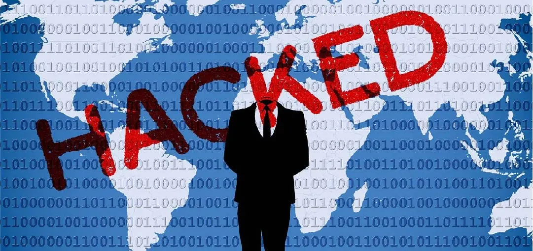 A figure in a suit stands with arms crossed against a backdrop of a world map and binary code, with the word "HACKED" prominently displayed in red across the image, symbolizing the global threat of cyber attacks and the importance of DNS security in preventing website hijacking and cyber crime.