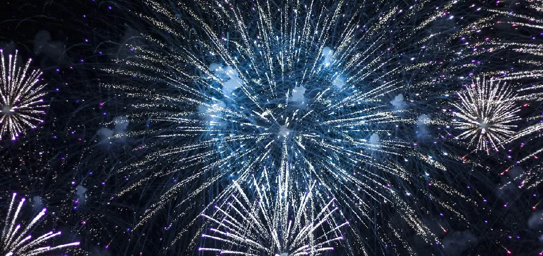 Colourful fireworks burst in the night sky, creating a dazzling display of lights and patterns, predominantly in blue and silver tones. The image symbolizes the launch of a new DNS monitoring platform designed to protect your DNS effectively.