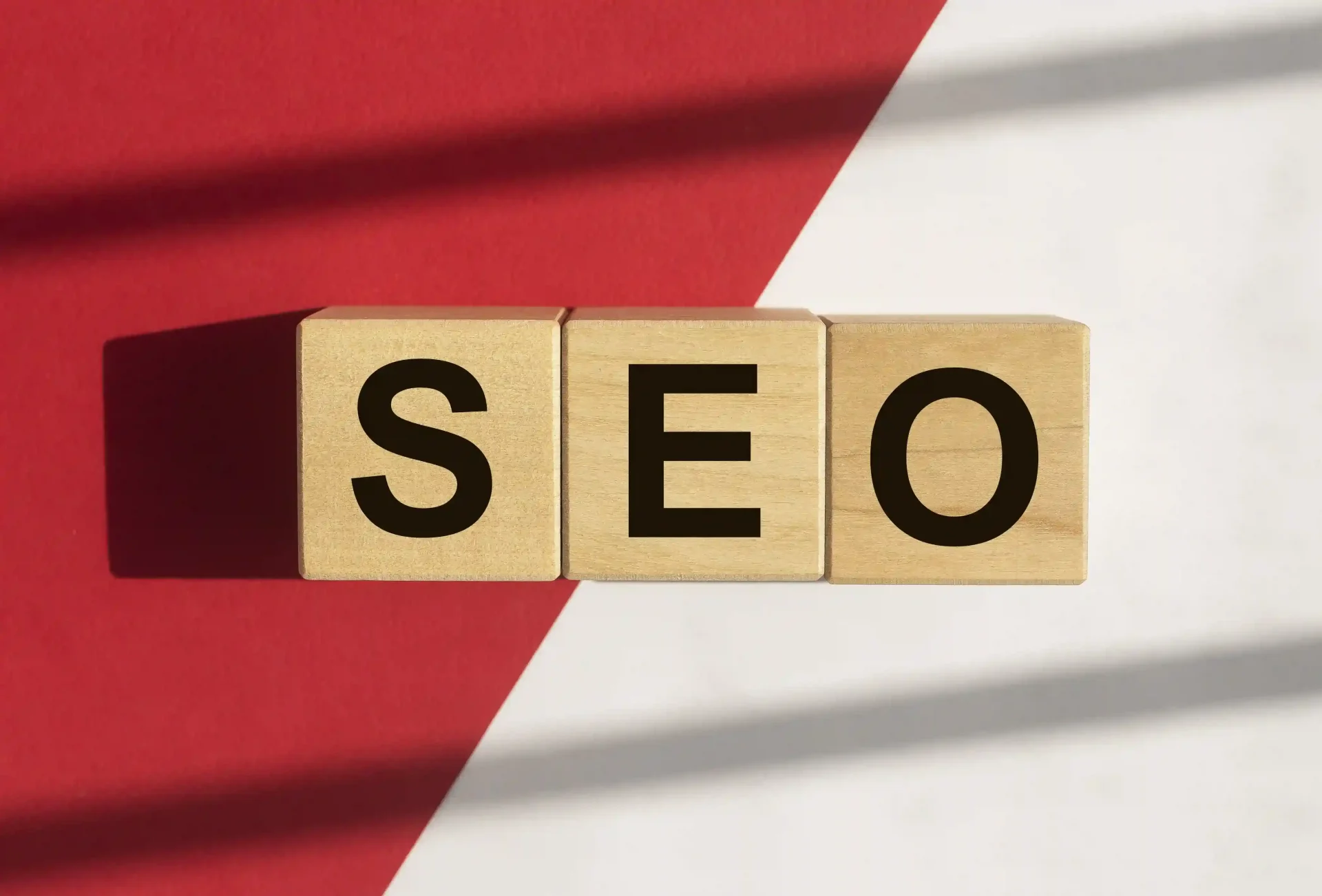 Wooden blocks spelling SEO on a contrasting background, symbolizing the strategic importance of search engine optimisation and its technical foundations.